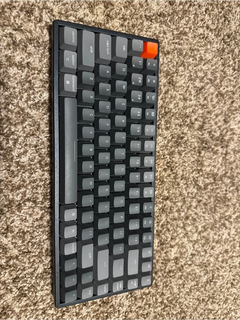 Compact Gray Mechanical Keyboard with Orange Accent Key